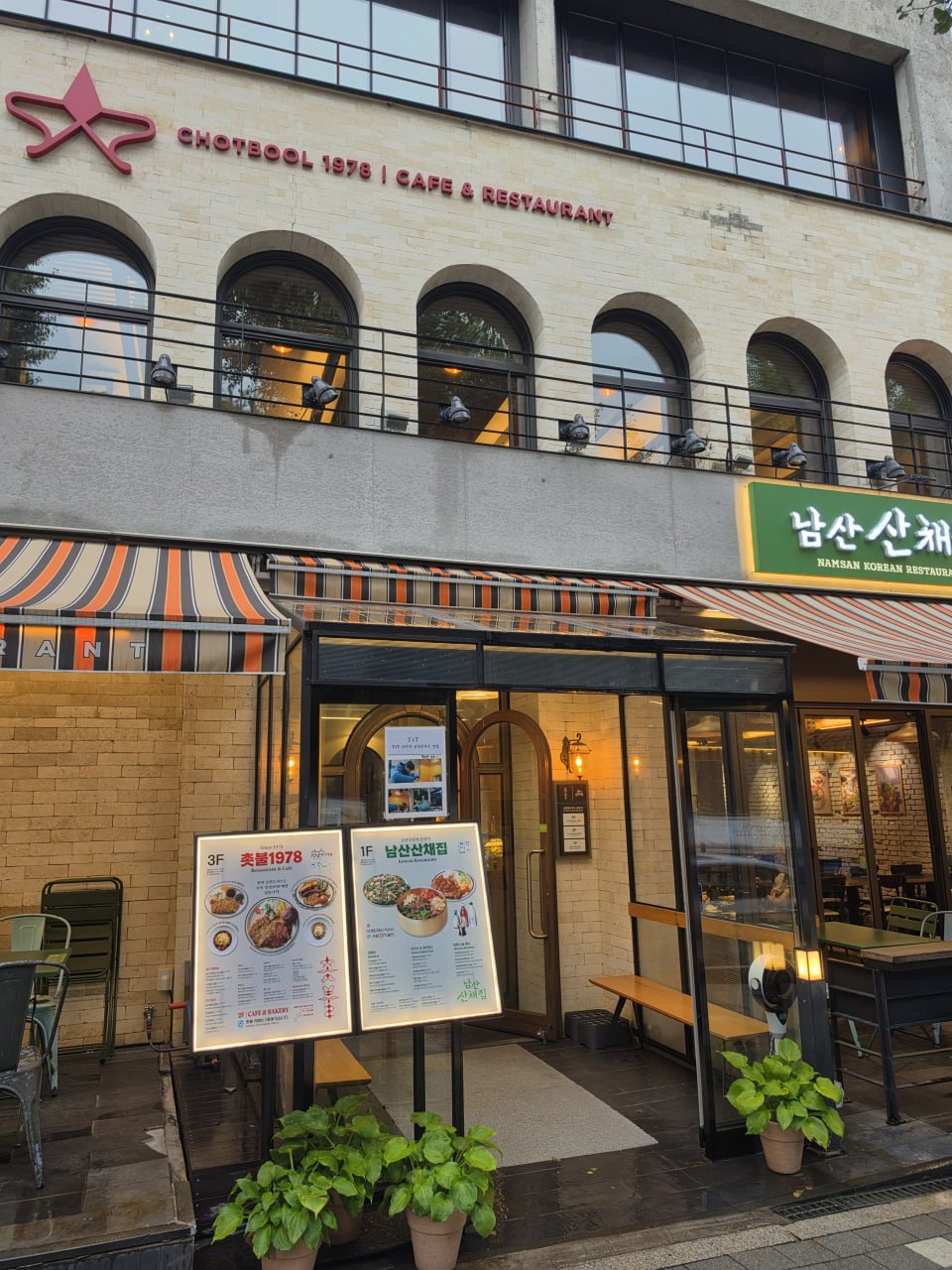 Front exterior with CHOTBOOL 1978 Cafe & Restaurant sign, entrance, and directory board