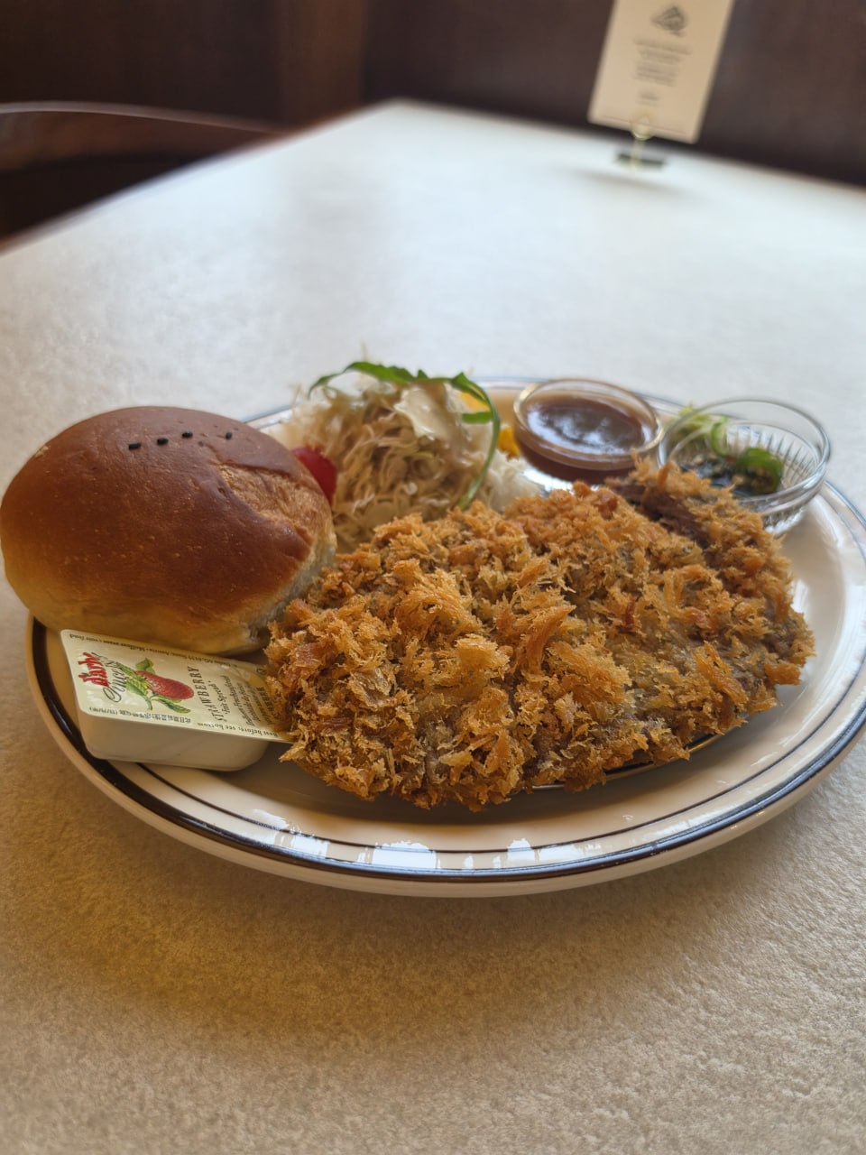 Crispy fried dish with a bun and salad at CHOTBOOL 1978